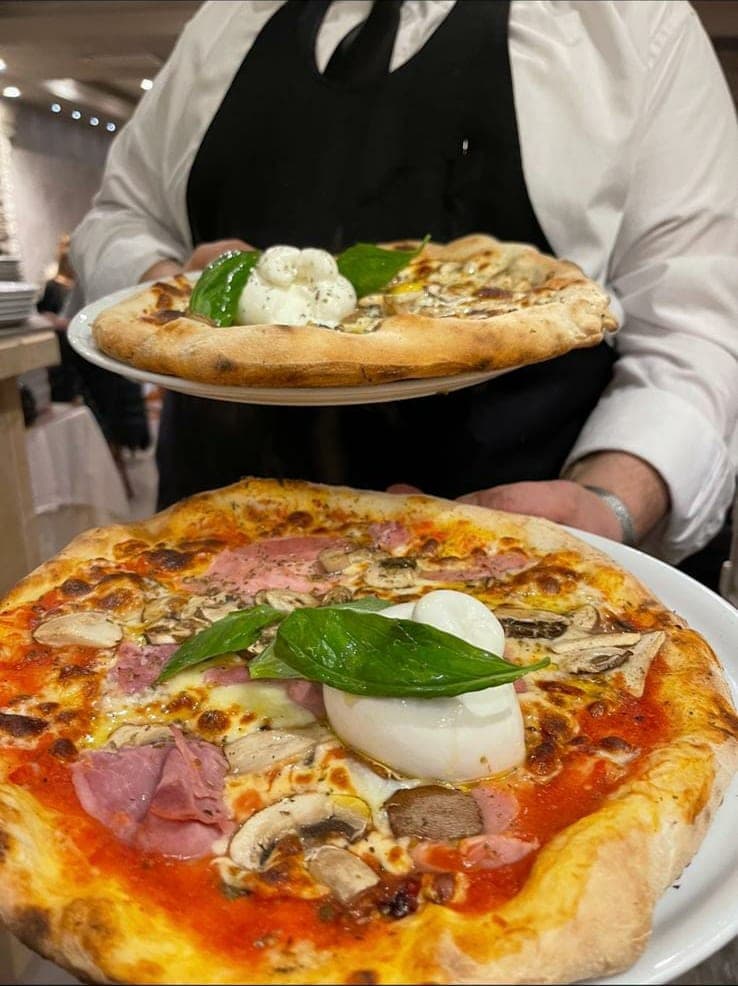 Deux pizzas garnies de burrata au moment du service